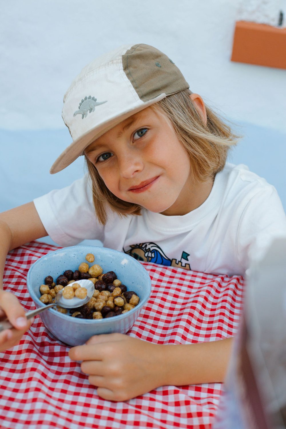 Smiling child with a bowl of Cheeky Pete's